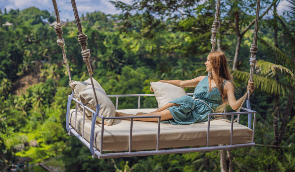 A lady swinging on a bed swing in Ubud