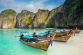 Thailand sea beach view round with steep limestone hills with many traditional longtail boats parking at Maya Bay, Ko Phi Phi Leh island, part of Krabi, Andaman Sea