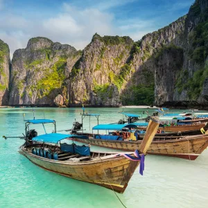 Thailand sea beach view round with steep limestone hills with many traditional longtail boats parking at Maya Bay, Ko Phi Phi Leh island, part of Krabi, Andaman Sea