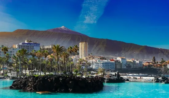skyline of Puerto de la Cruz with Teide volcano and pool water, Tenerife, Spain